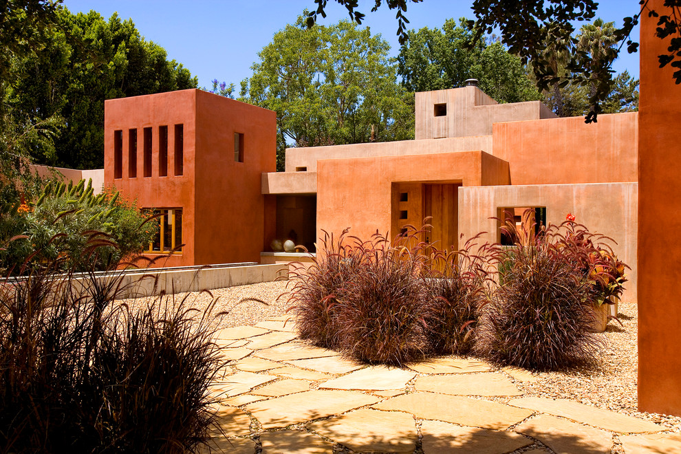 Imagen de fachada de casa naranja mediterránea grande de una planta con tejado plano