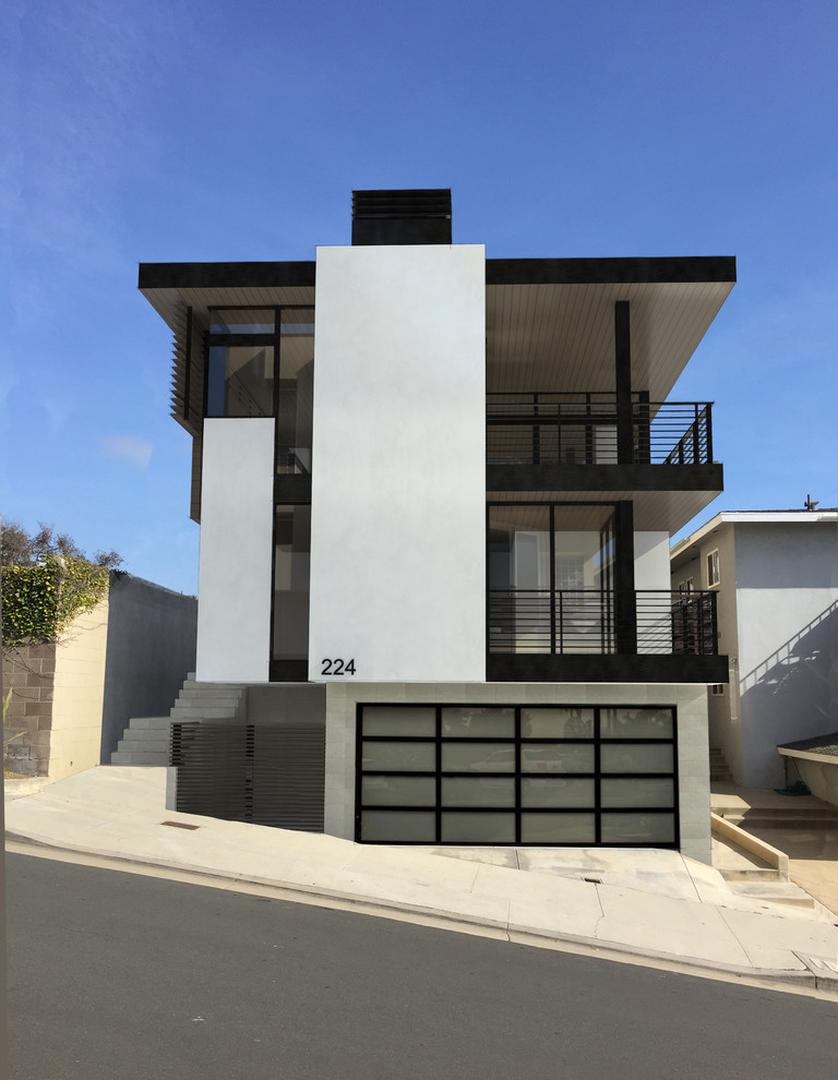 Photo of a large and white modern detached house in Los Angeles with three floors, wood cladding and a flat roof.