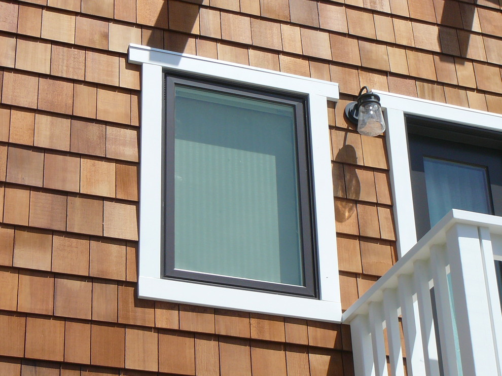 Réalisation d'une petite façade de maison marron craftsman en bois à un étage avec un toit à deux pans.