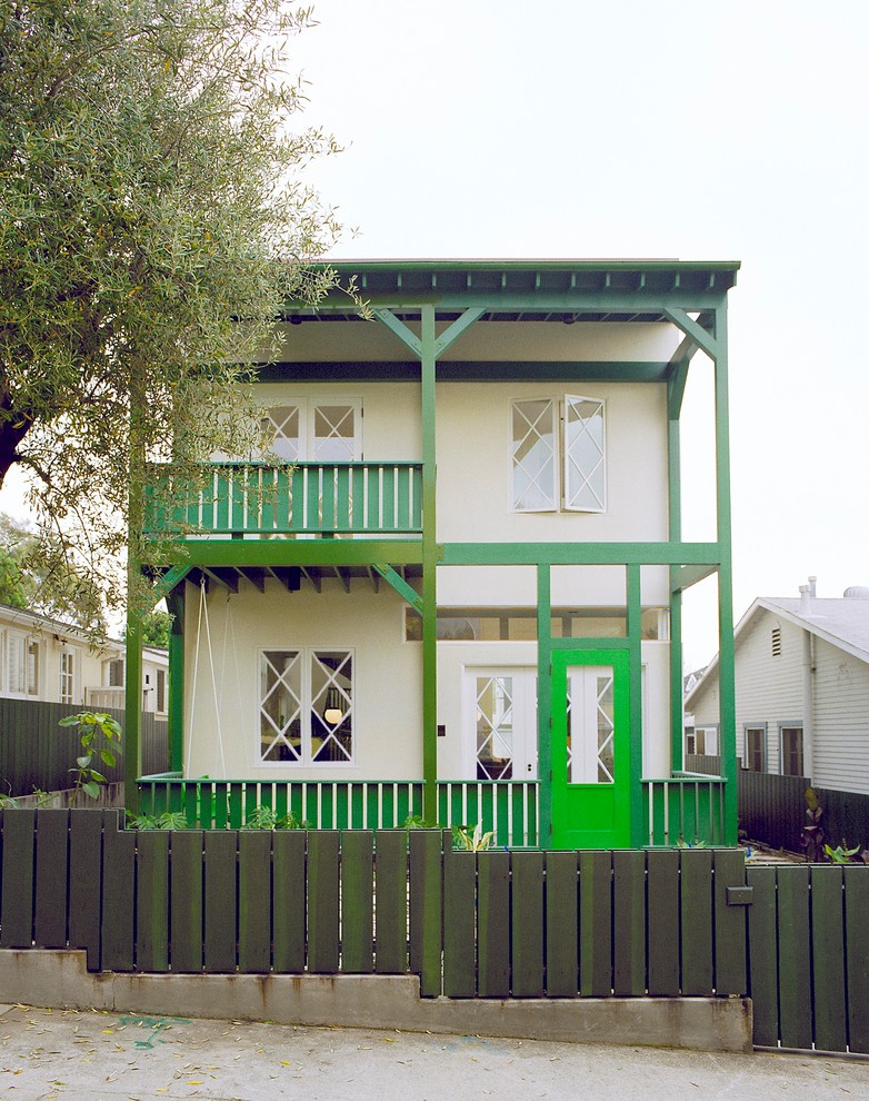 Exemple d'une façade de maison verte bord de mer à un étage.