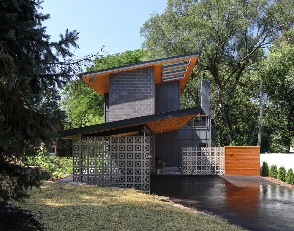 Cette image montre une façade de maison grise design à un étage avec un revêtement mixte et un toit en appentis.