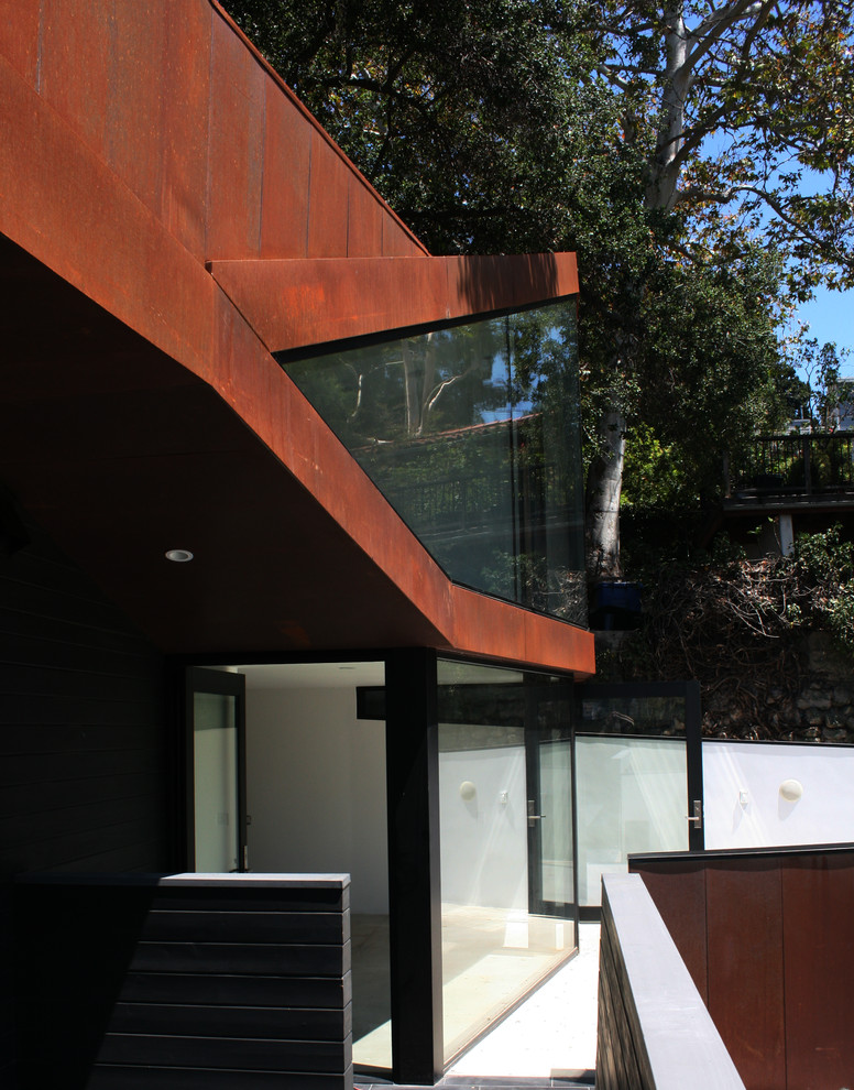 Modelo de fachada de casa multicolor actual pequeña de dos plantas con revestimiento de metal y tejado de metal