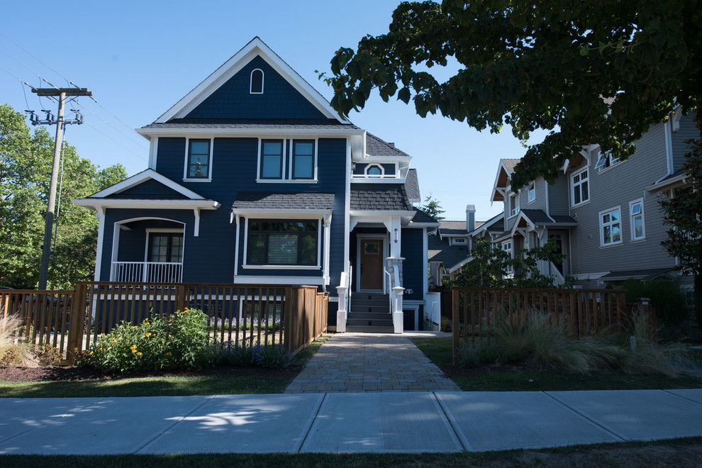 This is an example of a large and blue classic two floor house exterior in Vancouver with a hip roof.