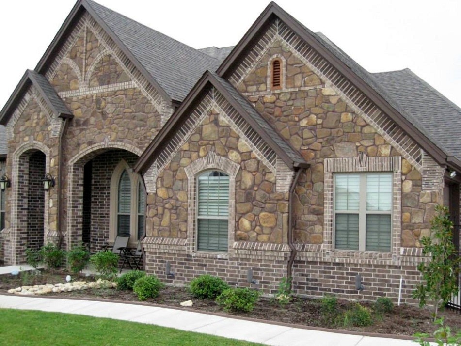 Inspiration for a rustic brown one-story stone house exterior remodel in Other with a shingle roof