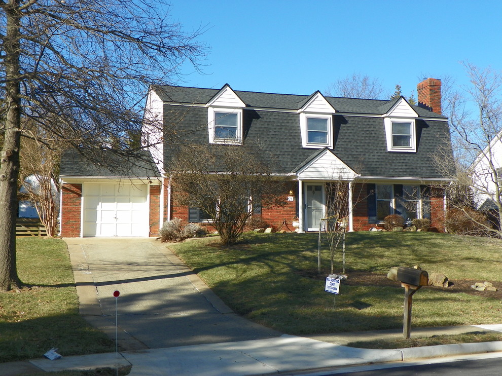 Medium sized and red classic two floor brick detached house in DC Metro with a shingle roof.