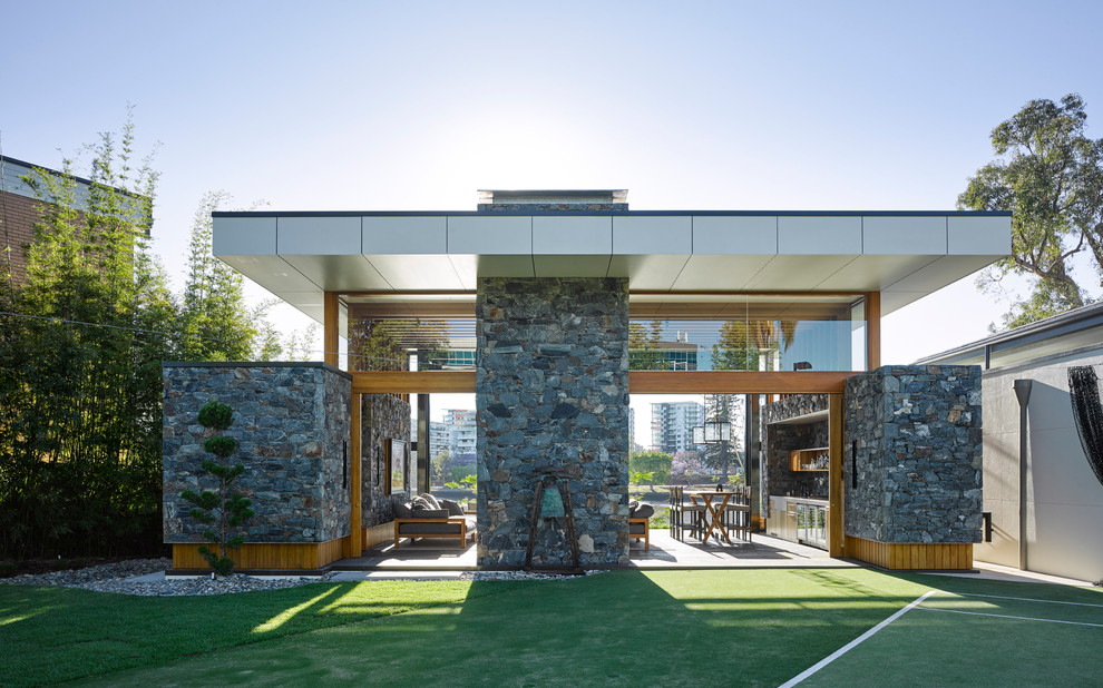 Inspiration pour une façade de maison grise minimaliste en pierre de taille moyenne et de plain-pied avec un toit plat.