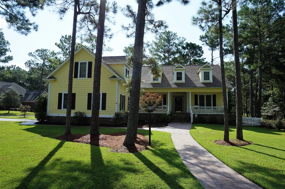 Mittelgroßes, Zweistöckiges Klassisches Einfamilienhaus mit Vinylfassade, gelber Fassadenfarbe, Walmdach und Schindeldach in Sonstige