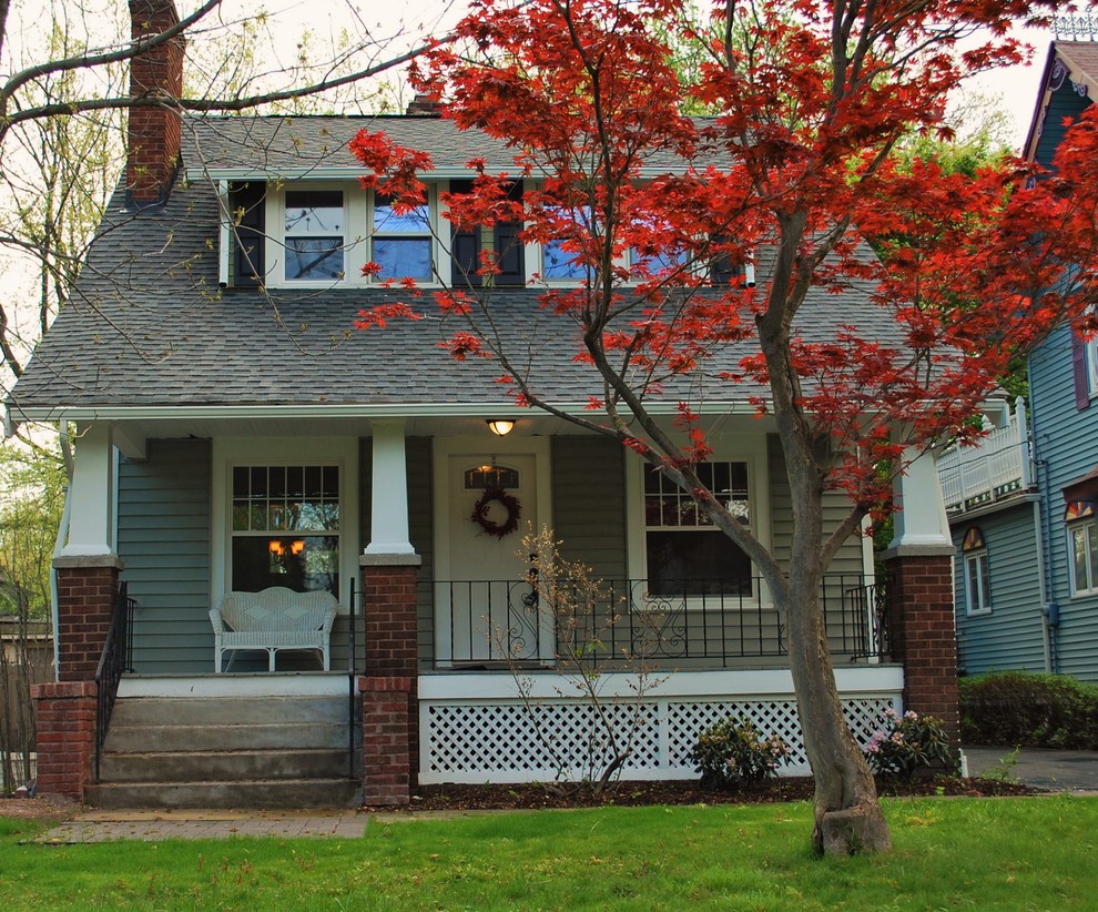 Example of a small classic green two-story wood gable roof design in Cleveland
