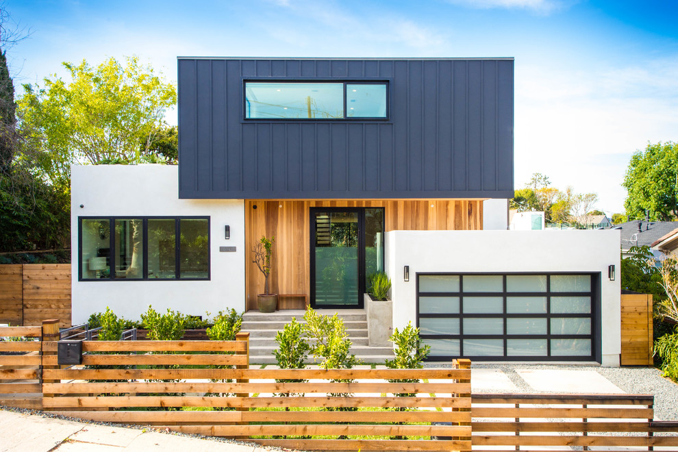 Réalisation d'une façade de maison multicolore marine à un étage avec un revêtement mixte et un toit plat.