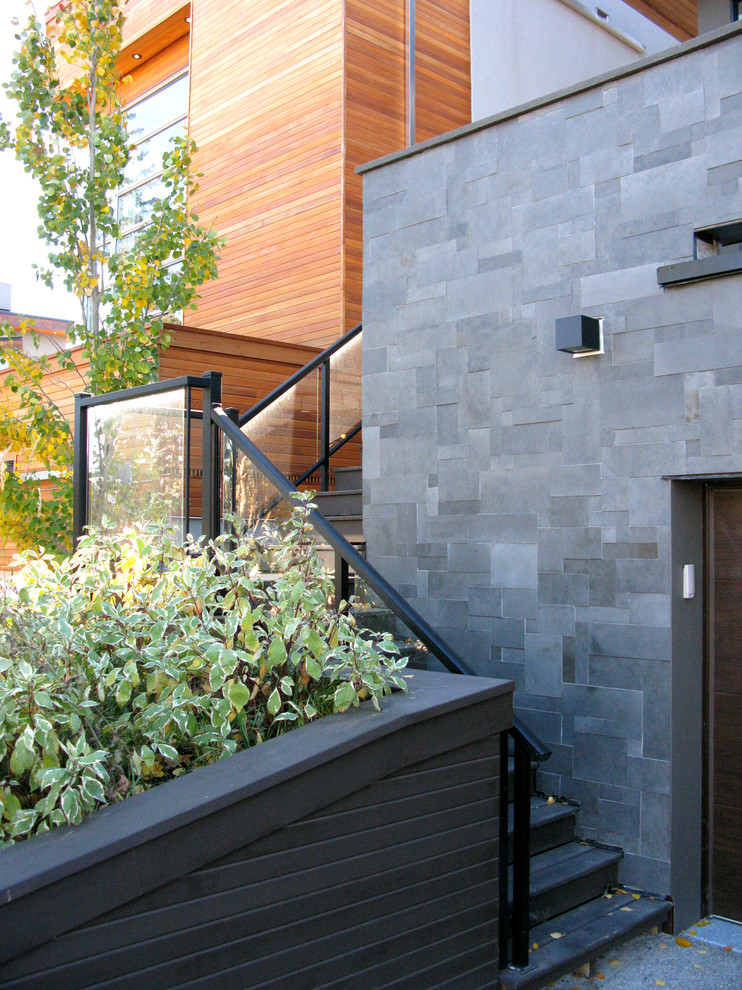 Modernes Haus mit Steinfassade, schwarzer Fassadenfarbe und Flachdach in Calgary