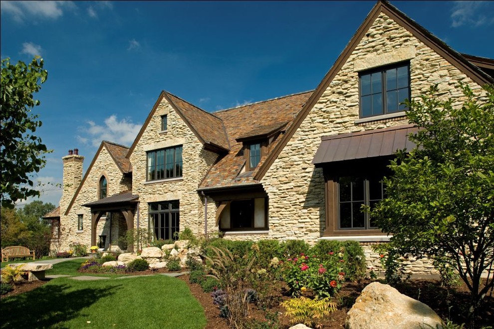 Inspiration for a rustic two floor house exterior in Chicago with stone cladding.