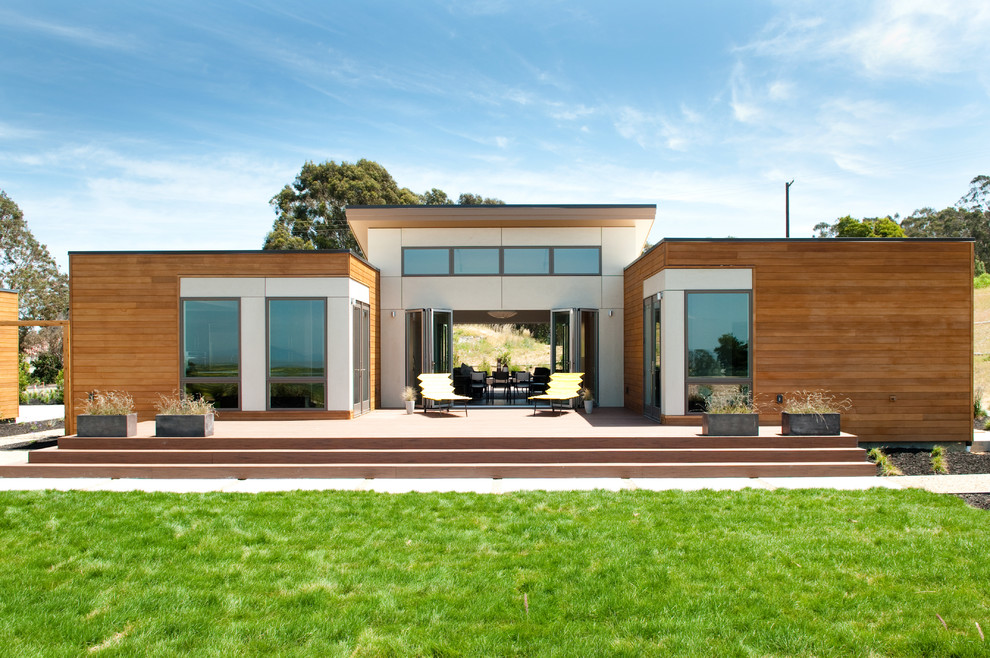 Diseño de fachada marrón actual de tamaño medio de una planta con revestimiento de madera y tejado plano