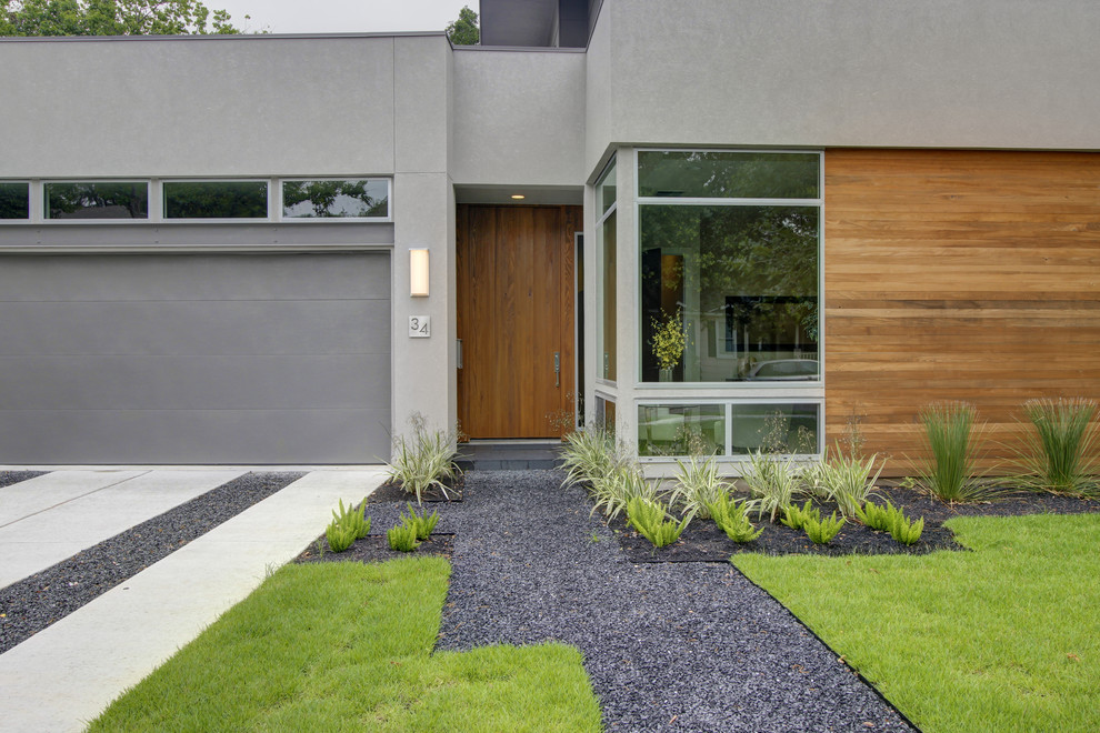Mittelgroßes, Zweistöckiges Modernes Haus mit Putzfassade, grauer Fassadenfarbe und Flachdach in Austin