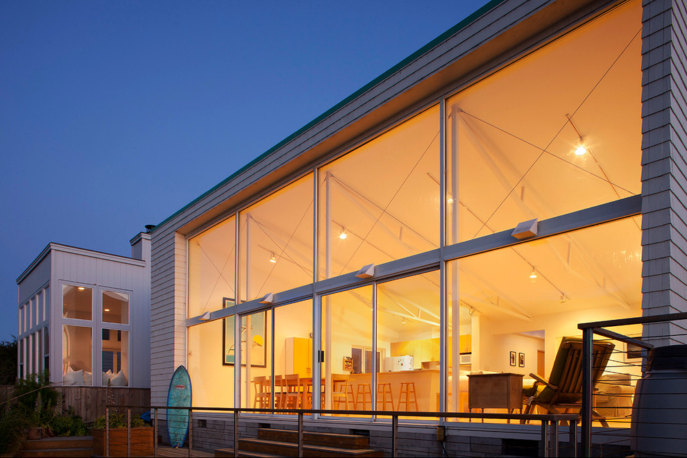 Idéer för ett maritimt grått hus, med allt i ett plan, glasfasad och platt tak
