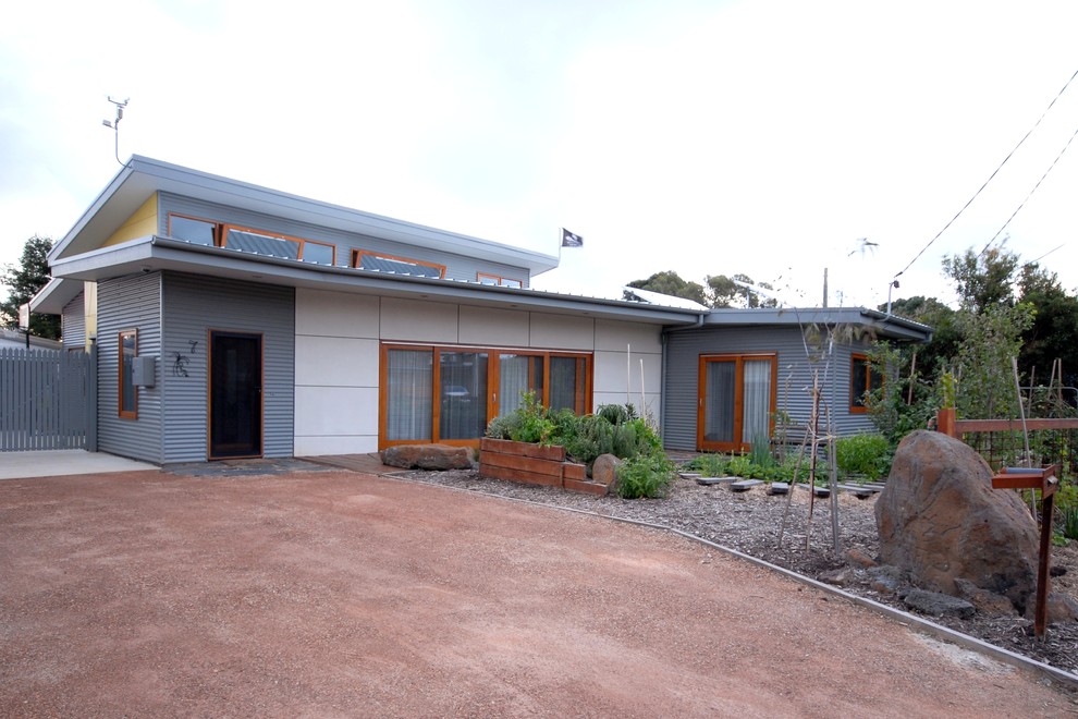 Exemple d'une façade de maison multicolore tendance en panneau de béton fibré de taille moyenne et à un étage avec un toit plat et un toit en métal.