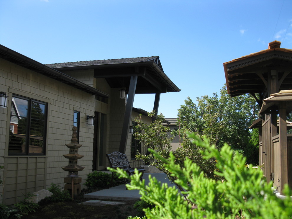 Réalisation d'une façade de maison beige asiatique en bois de taille moyenne et de plain-pied avec un toit à deux pans et un toit en shingle.