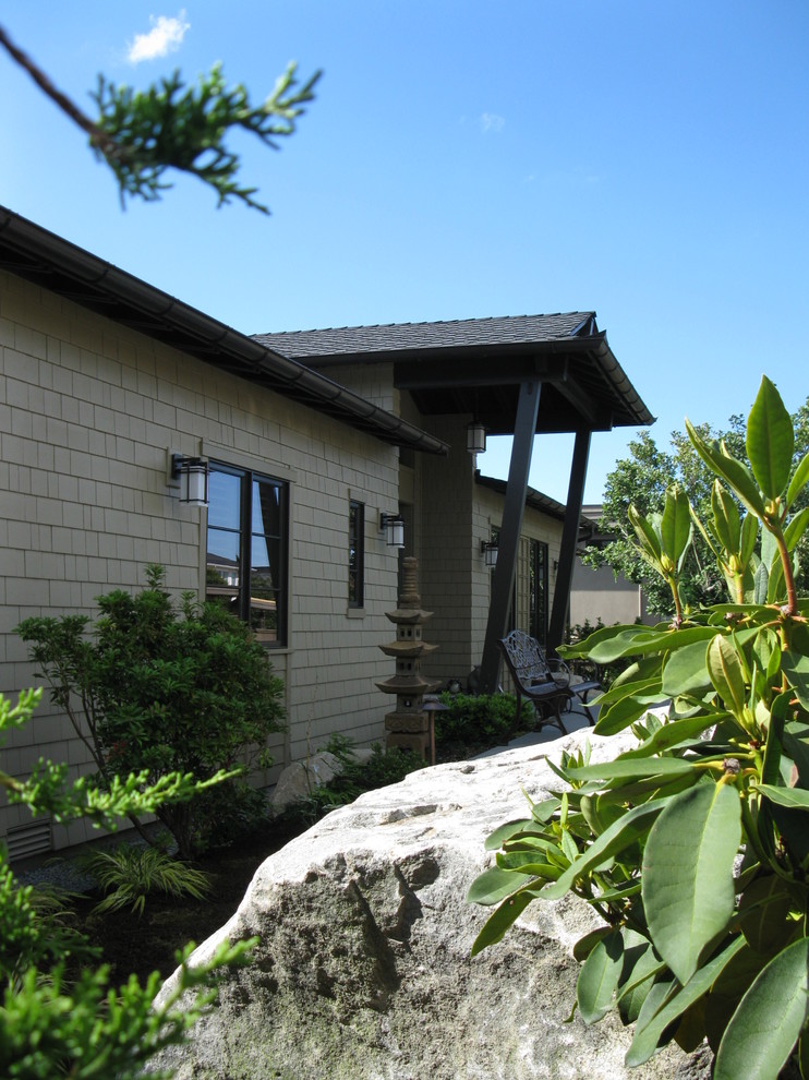 Ejemplo de fachada de casa beige de estilo zen de tamaño medio de una planta con revestimiento de madera, tejado a dos aguas y tejado de teja de madera