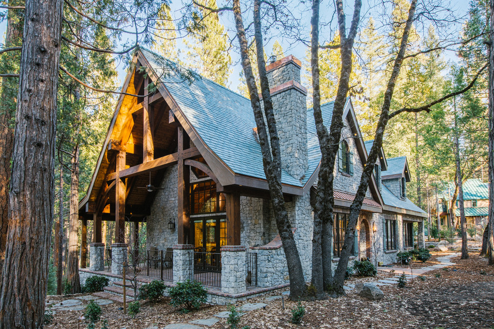 Diseño de fachada de casa gris rural de dos plantas con revestimiento de piedra, tejado a dos aguas y tejado de teja de madera