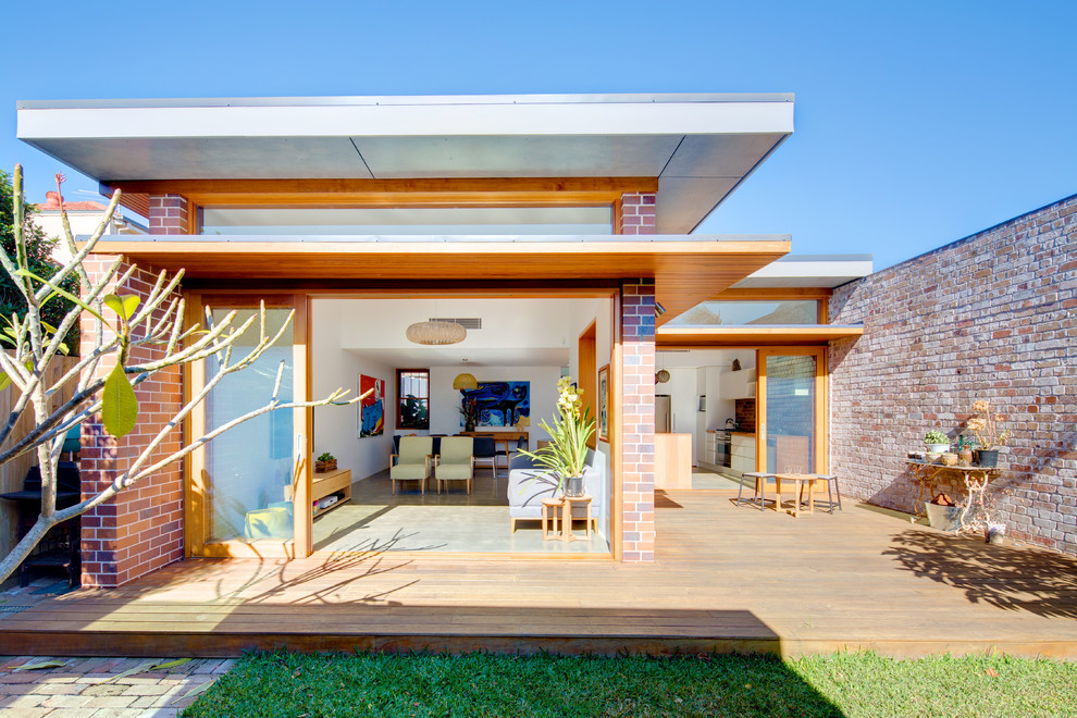 Réalisation d'une façade de maison minimaliste en brique de plain-pied avec un toit plat.