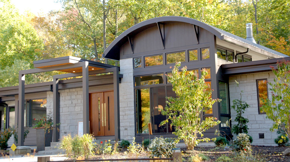 Réalisation d'une grande façade de maison beige minimaliste en pierre de plain-pied avec un toit plat.
