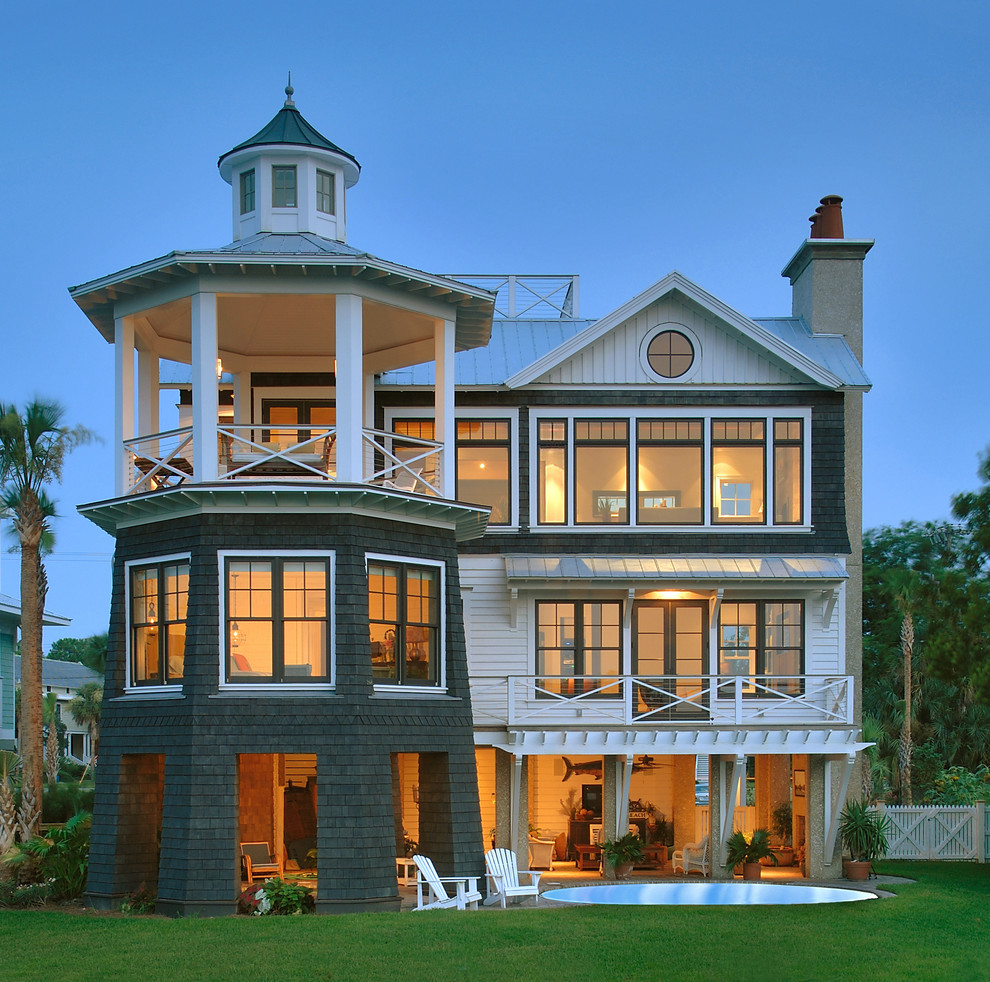 Idées déco pour une façade de maison verte bord de mer en bois à deux étages et plus.