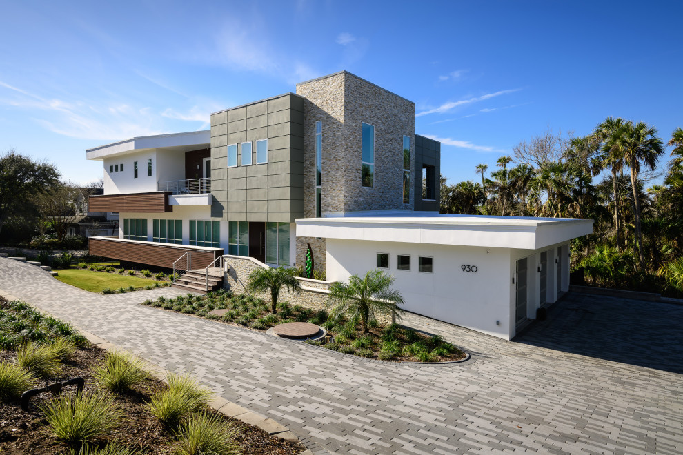 Imagen de fachada de casa multicolor contemporánea grande de dos plantas con revestimientos combinados y tejado plano