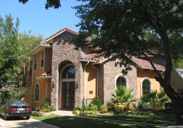 Immagine della facciata di una casa marrone eclettica con rivestimento in pietra
