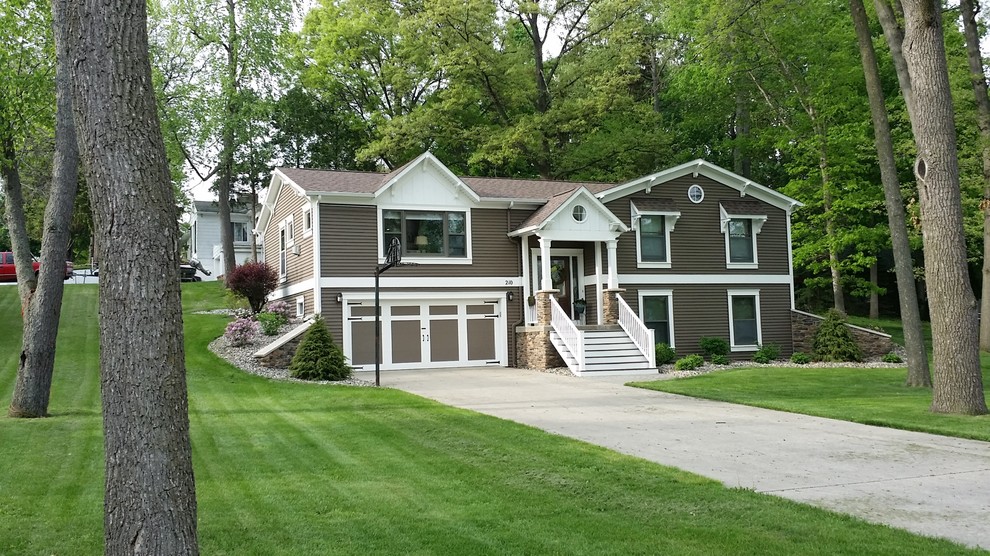 Foto de fachada gris de estilo americano de tamaño medio a niveles con revestimiento de vinilo y tejado a dos aguas