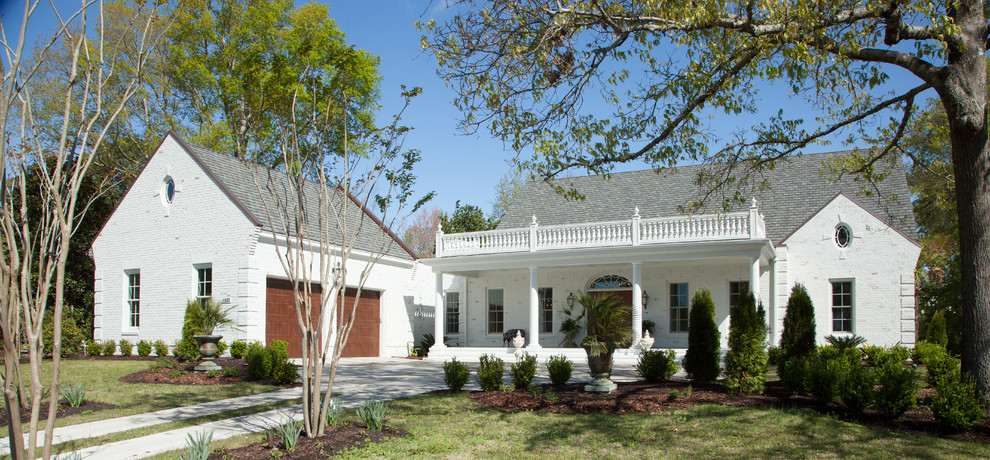 На фото: двухэтажный, кирпичный, белый дом среднего размера в классическом стиле с