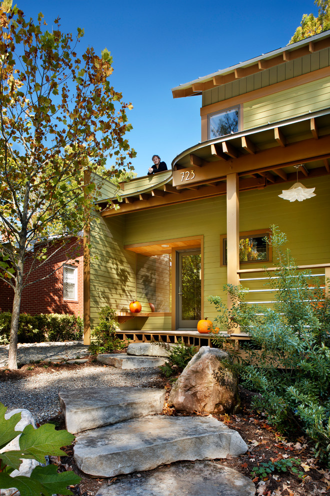 Imagen de fachada verde actual de dos plantas con revestimiento de madera