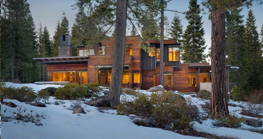 Cette image montre une grande façade de maison marron minimaliste en bois à un étage avec un toit plat et un toit en shingle.