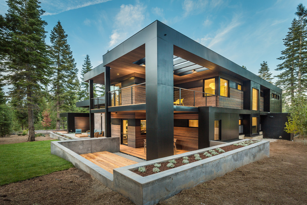 Inspiration pour une façade de maison noire design à un étage avec un revêtement mixte et un toit plat.