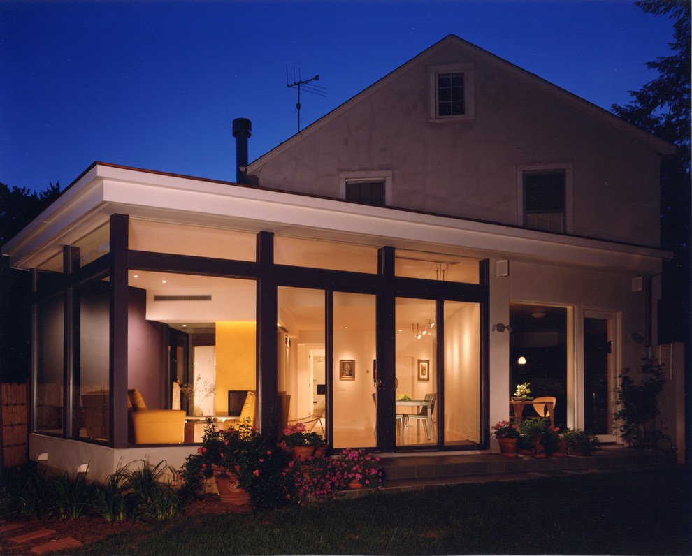 Diseño de fachada blanca moderna de tamaño medio a niveles con revestimiento de vidrio y tejado plano