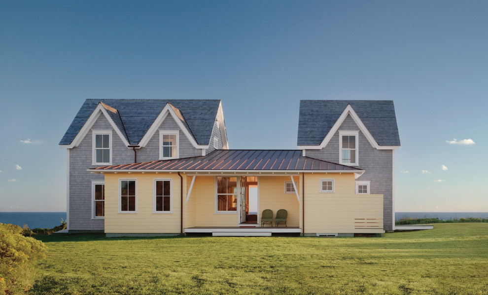 Стильный дизайн: огромный, двухэтажный, желтый дом в современном стиле с комбинированной облицовкой и двускатной крышей - последний тренд