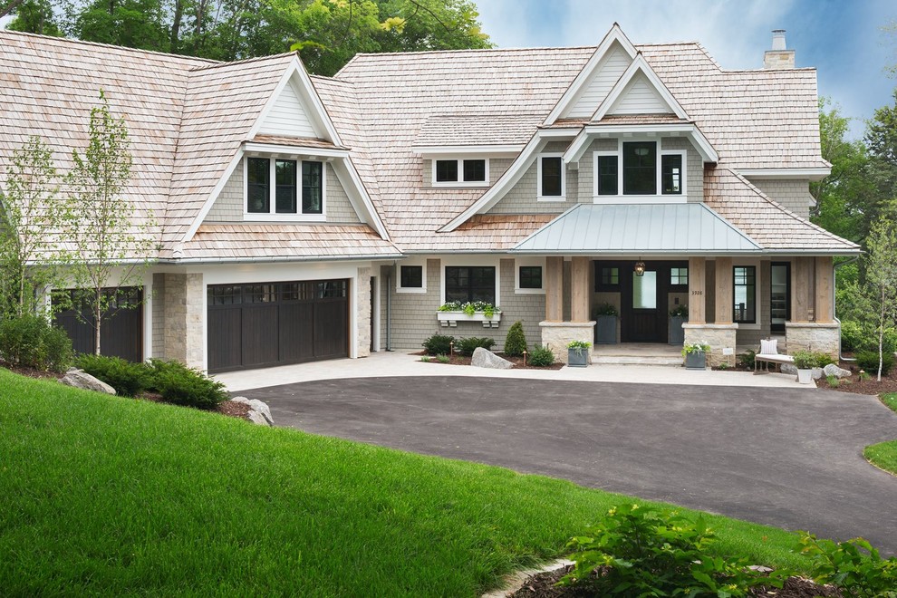 Cette photo montre une grande façade de maison grise tendance en bois à un étage avec un toit en shingle.