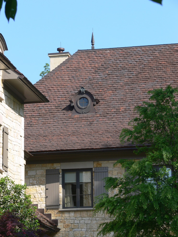 Réalisation d'une grande façade de maison beige victorienne en pierre à deux étages et plus avec un toit à quatre pans et un toit en tuile.