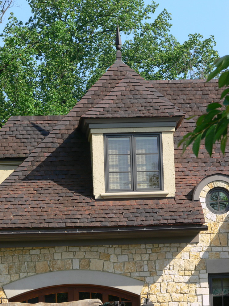 Foto de fachada de casa beige tradicional grande de tres plantas con revestimiento de piedra, tejado a cuatro aguas y tejado de teja de barro