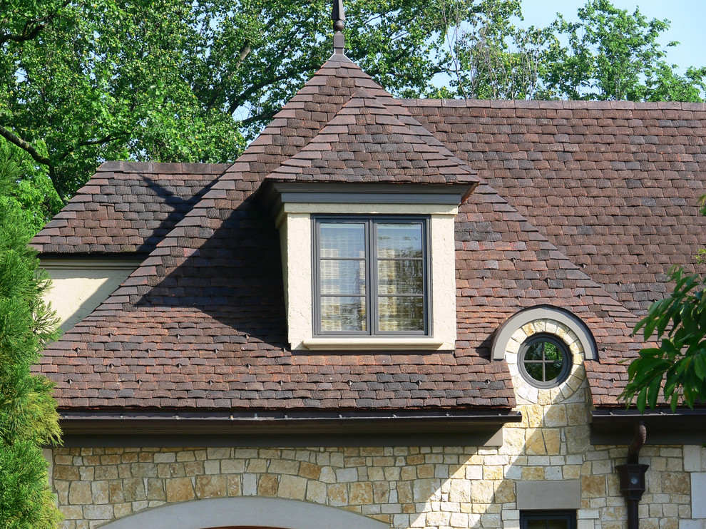 Modelo de fachada de casa beige clásica grande de tres plantas con revestimiento de piedra, tejado a cuatro aguas y tejado de teja de barro