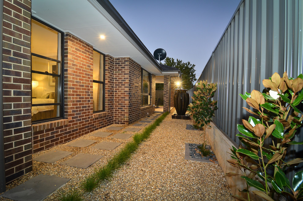 Inspiration for a mid-sized contemporary beige one-story brick exterior home remodel in Sydney