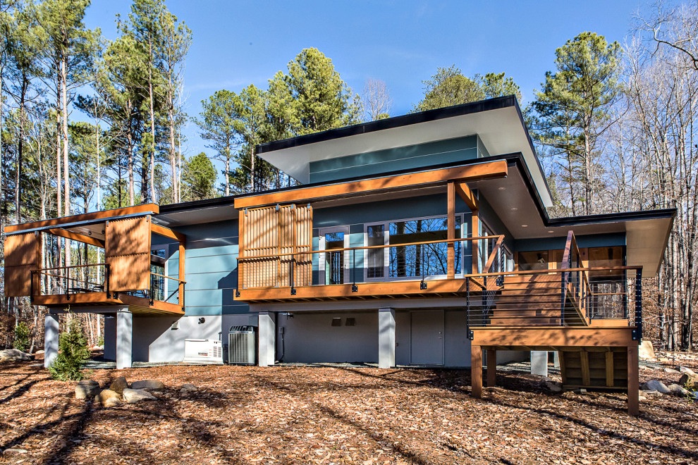 Inspiration pour une façade de maison bleue vintage en panneau de béton fibré de taille moyenne et de plain-pied avec un toit plat et un toit végétal.