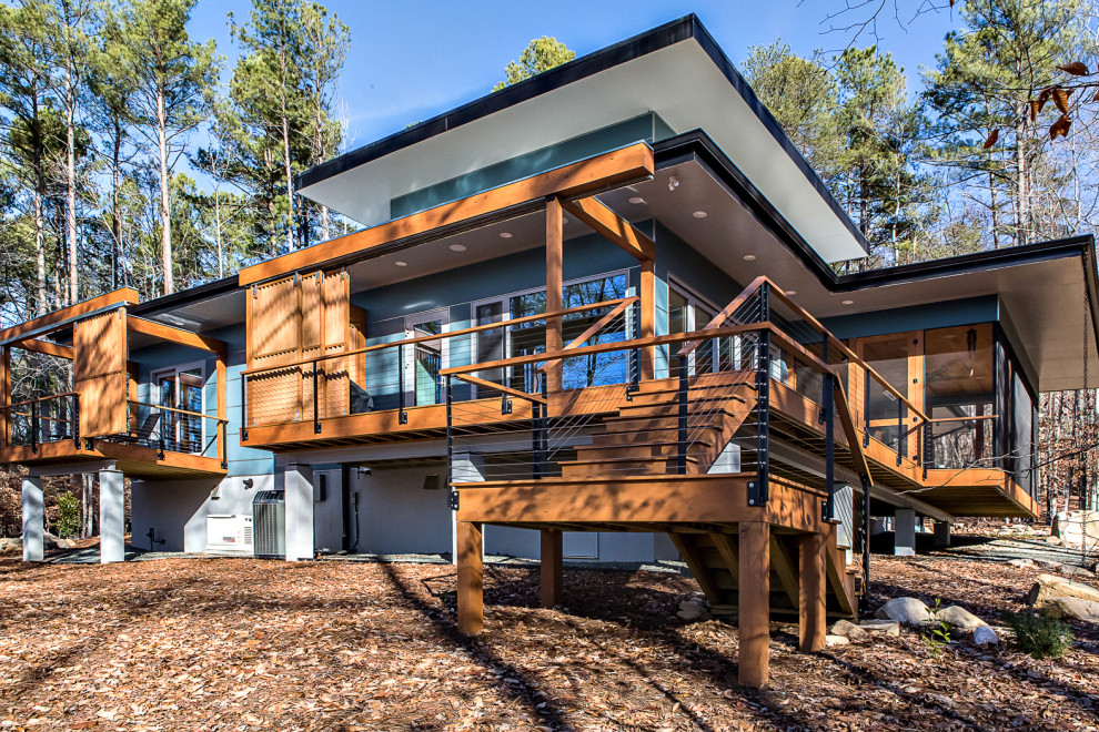 Idées déco pour une façade de maison bleue rétro en panneau de béton fibré de taille moyenne et de plain-pied avec un toit plat et un toit végétal.