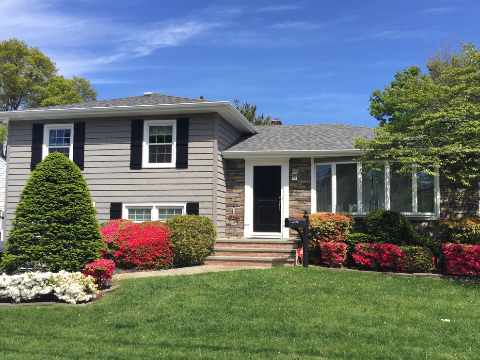 Example of a gray vinyl exterior home design in New York