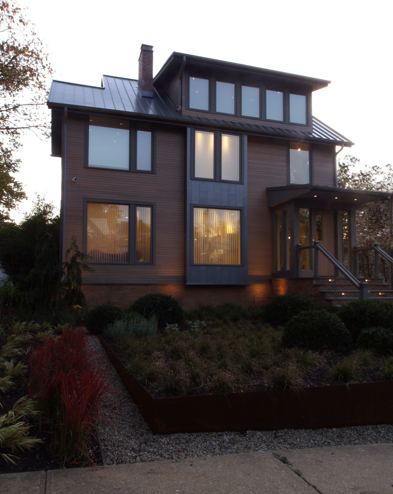 Exemple d'une façade de maison marron industrielle de taille moyenne et à deux étages et plus avec un revêtement mixte, un toit à deux pans et un toit en métal.