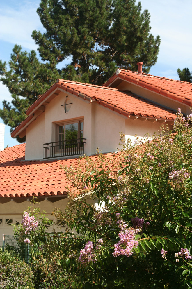 Modelo de fachada beige mediterránea de tamaño medio de dos plantas con revestimiento de vidrio y tejado a dos aguas
