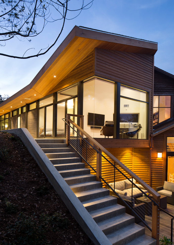 Réalisation d'une grande façade de maison marron design en bois à deux étages et plus avec un toit en shingle.