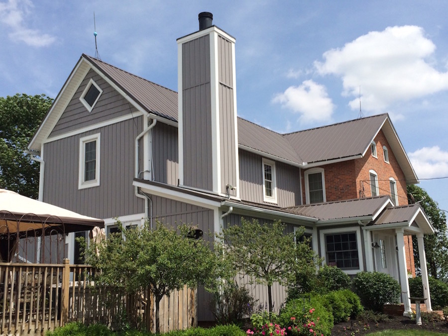 Exemple d'une façade de maison grise éclectique de taille moyenne et à un étage avec un revêtement en vinyle.