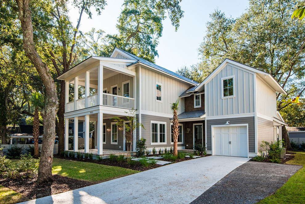 Cette photo montre une façade de maison grise bord de mer de taille moyenne et à un étage avec un revêtement mixte, un toit à deux pans et un toit en métal.