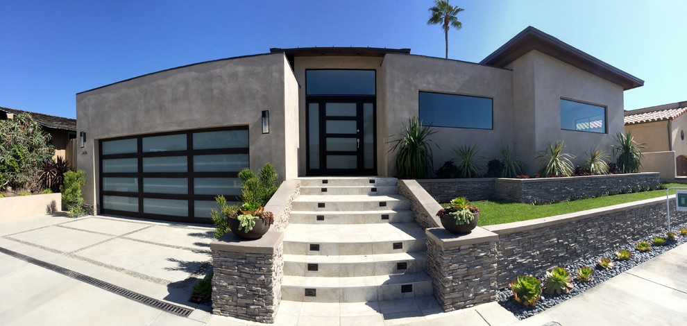 This is an example of a medium sized and gey modern split-level concrete detached house in Orange County with a flat roof.