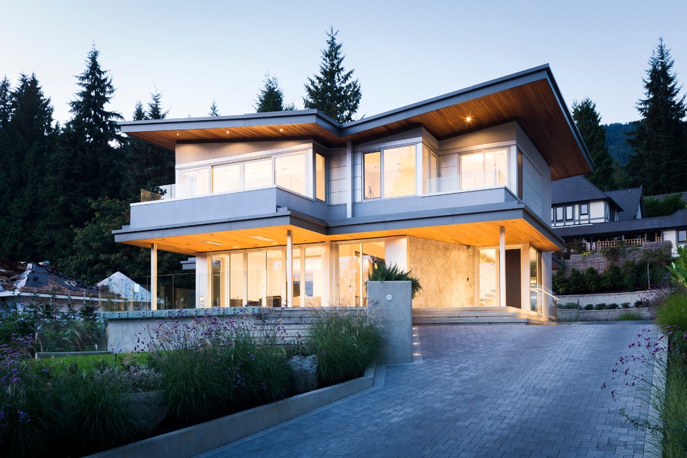 Réalisation d'une grande façade de maison grise design à deux étages et plus avec un revêtement mixte et un toit en appentis.