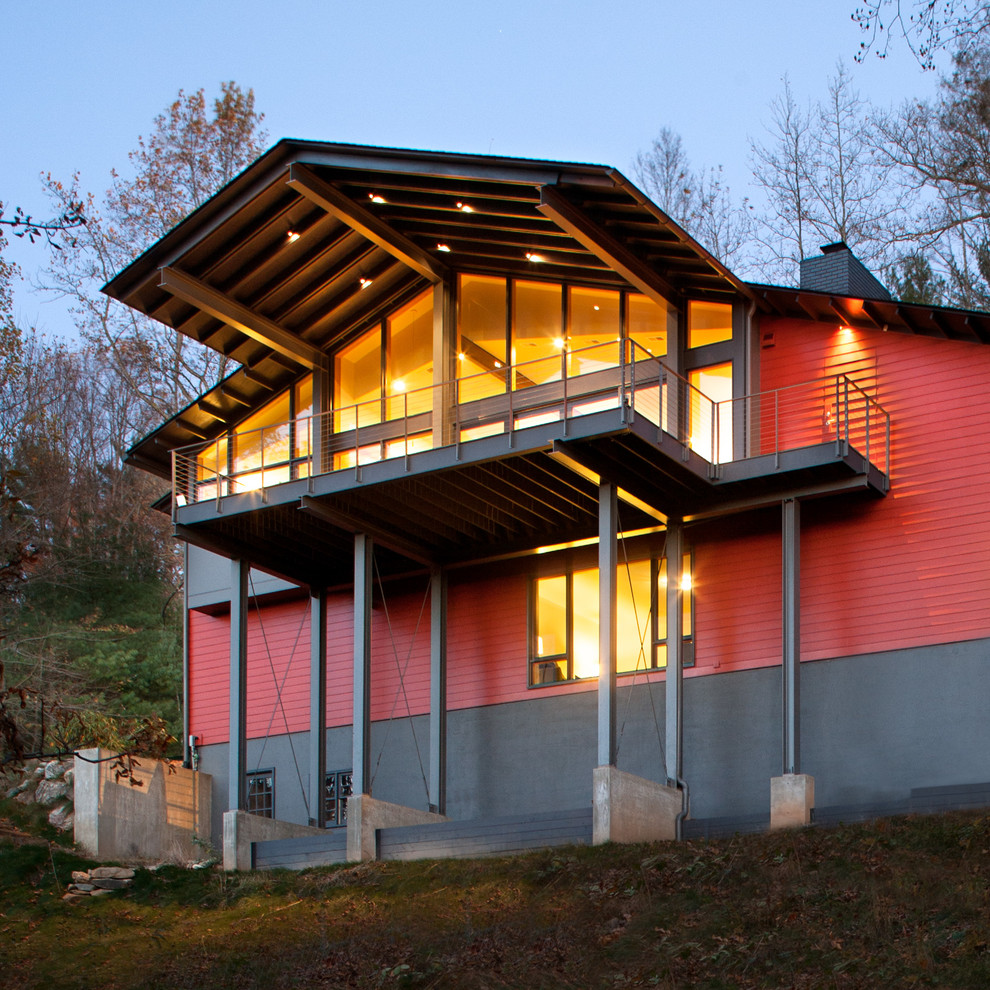 Aménagement d'une grande façade de maison rouge contemporaine à un étage avec un revêtement mixte, un toit à deux pans et un toit en shingle.